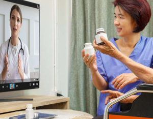 nurse with elderly woman video conference with doctor on monitor