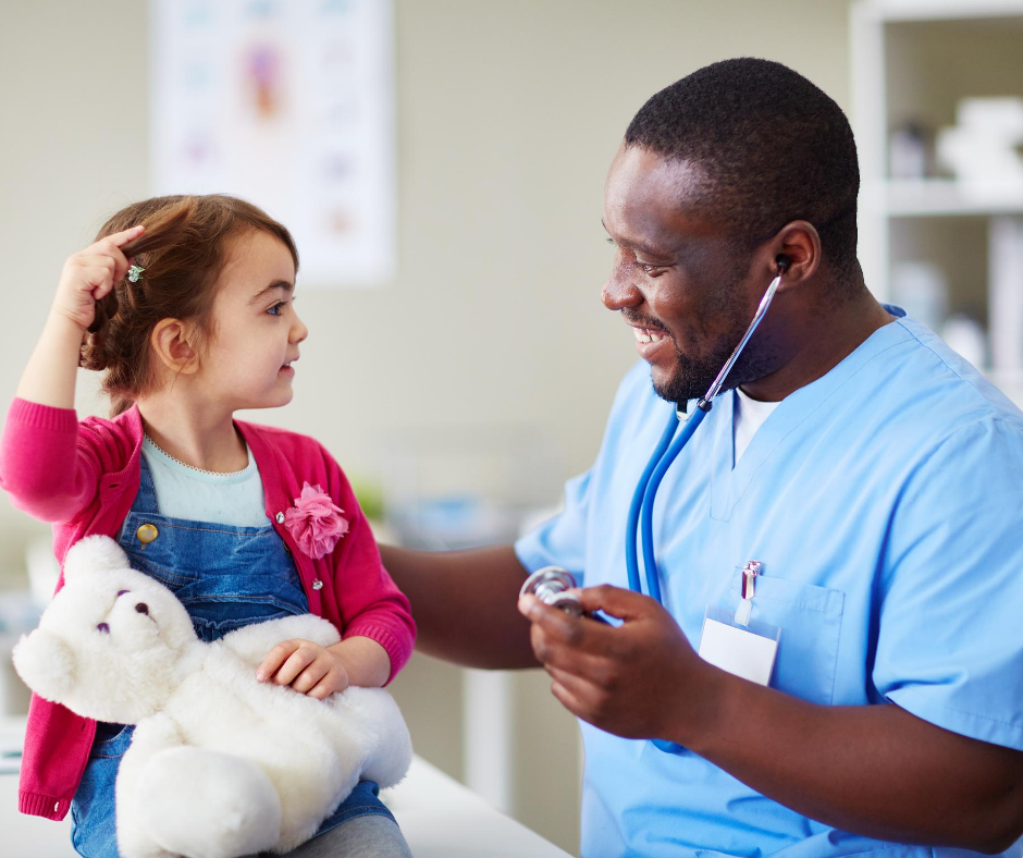 A male doctor talking to a child in hospital